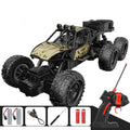 Gold RC crawler and its pictured controller and charging accessories.