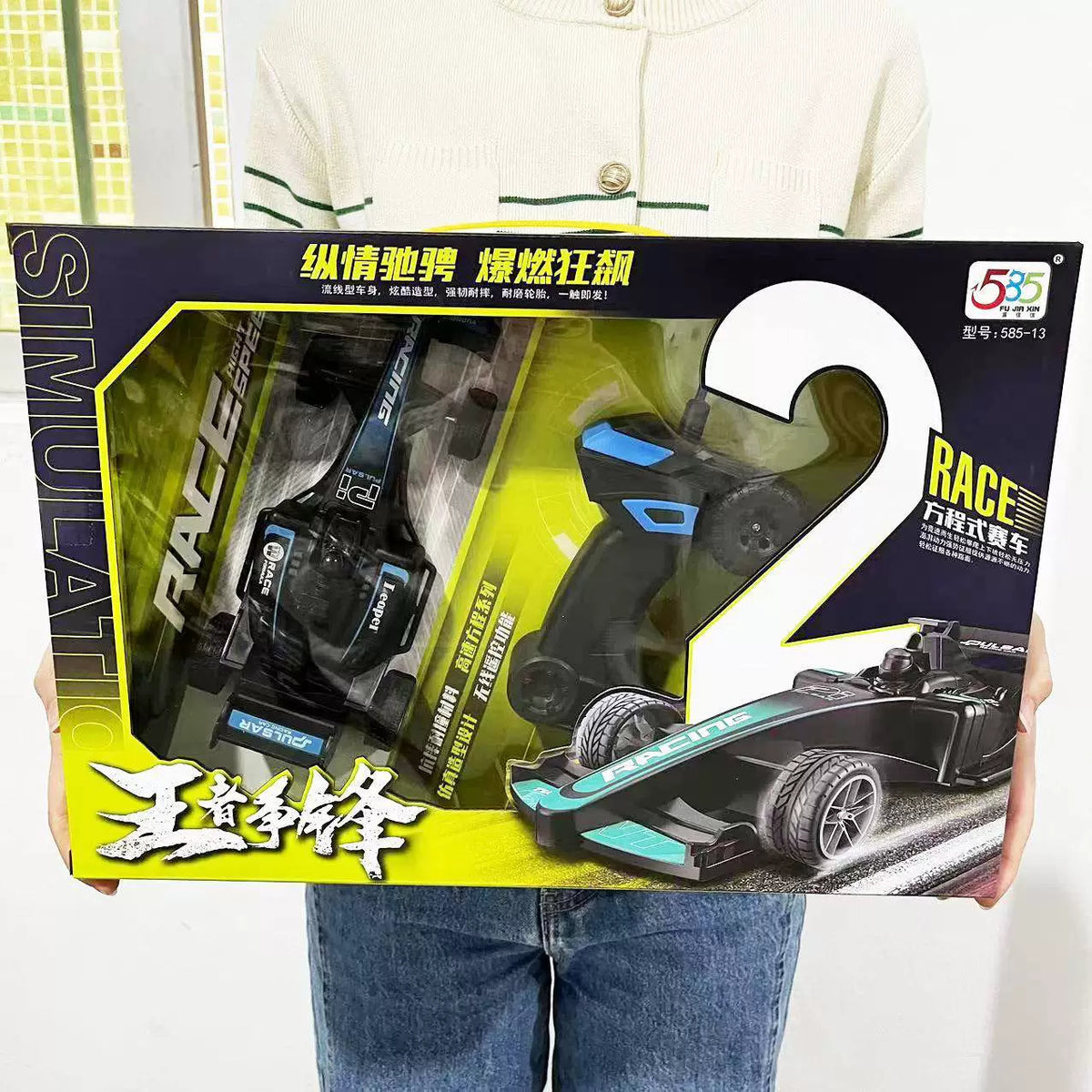 Formula-style car and physical pistol-style controller in the source retail package.