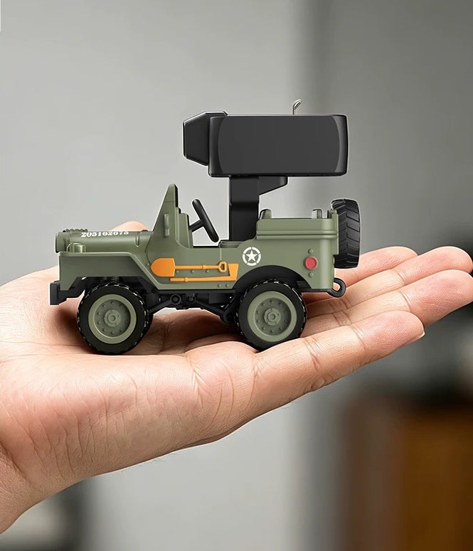 Side view of the green RC Jeep and camera module held in a hand