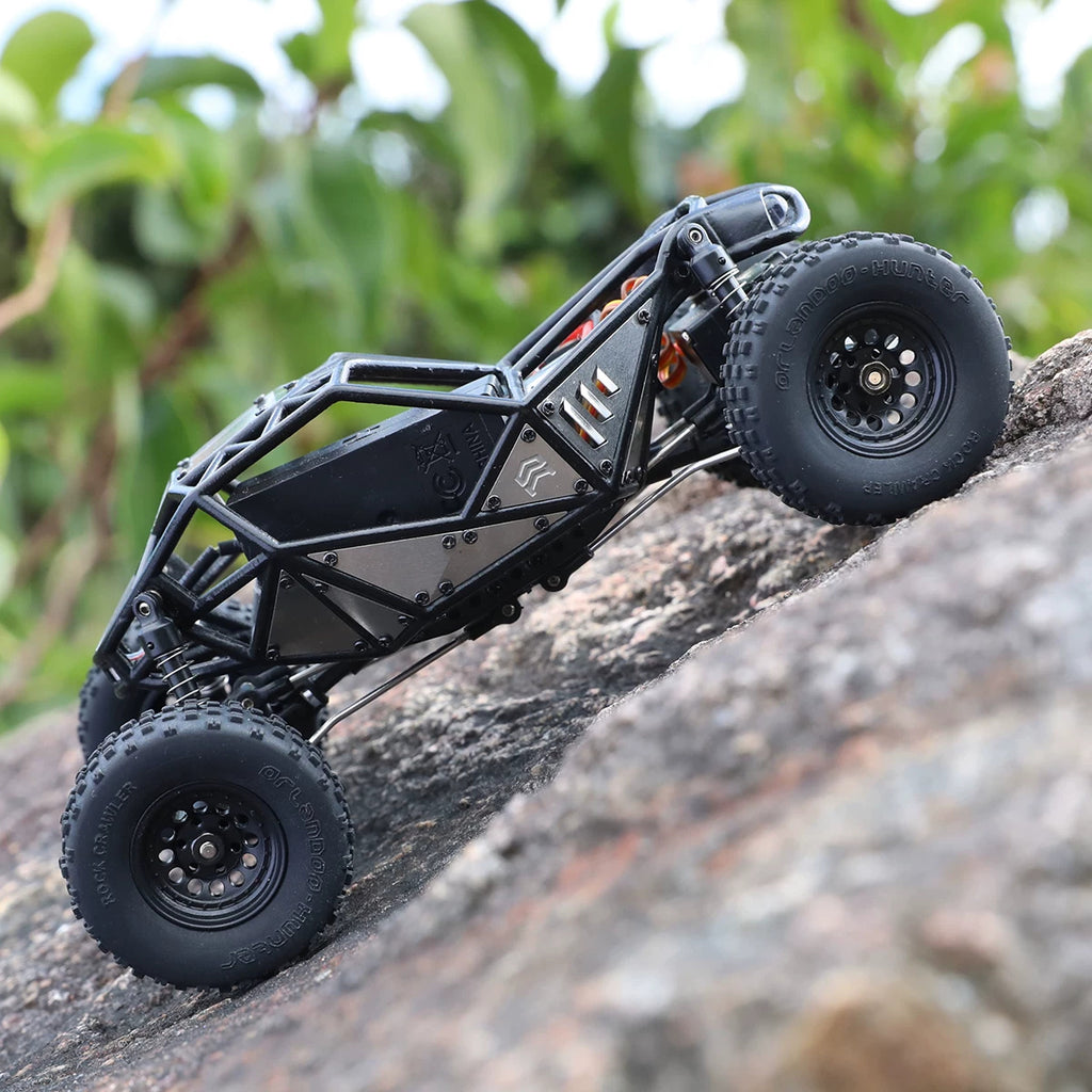 Assembled X01 crawler chassis shown side-on on a rock