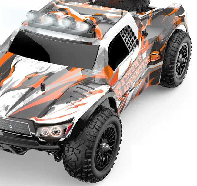 Orange EXTREME ADVENTURE RC truck, body and front-wheel detail crop